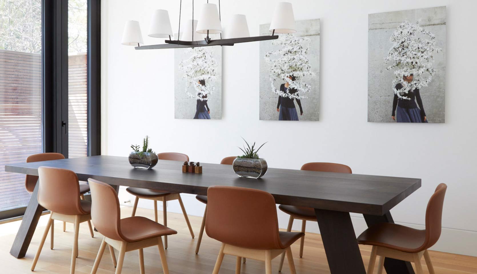 Custom pendant lighting with small white light covers above large dining table