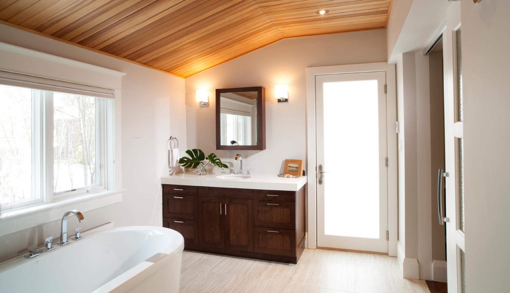 Luxury bathroom with vaulted wood ceiling and soaker tub