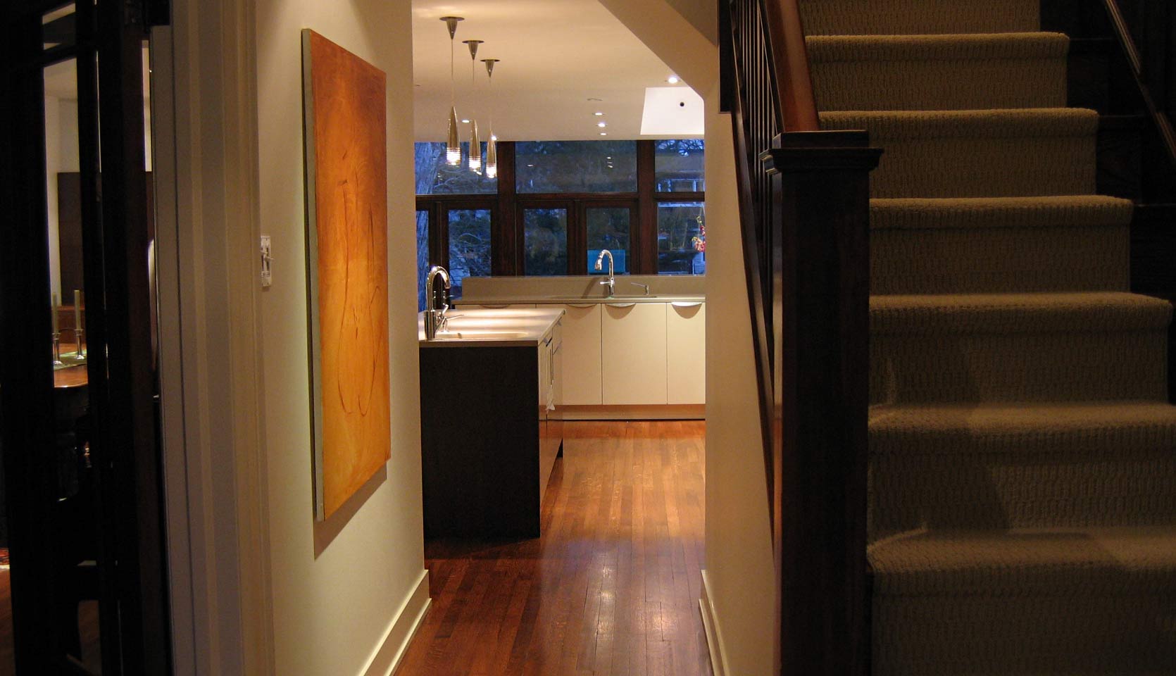 View of staircase leading up to the second story and shot of kitchen island and sink