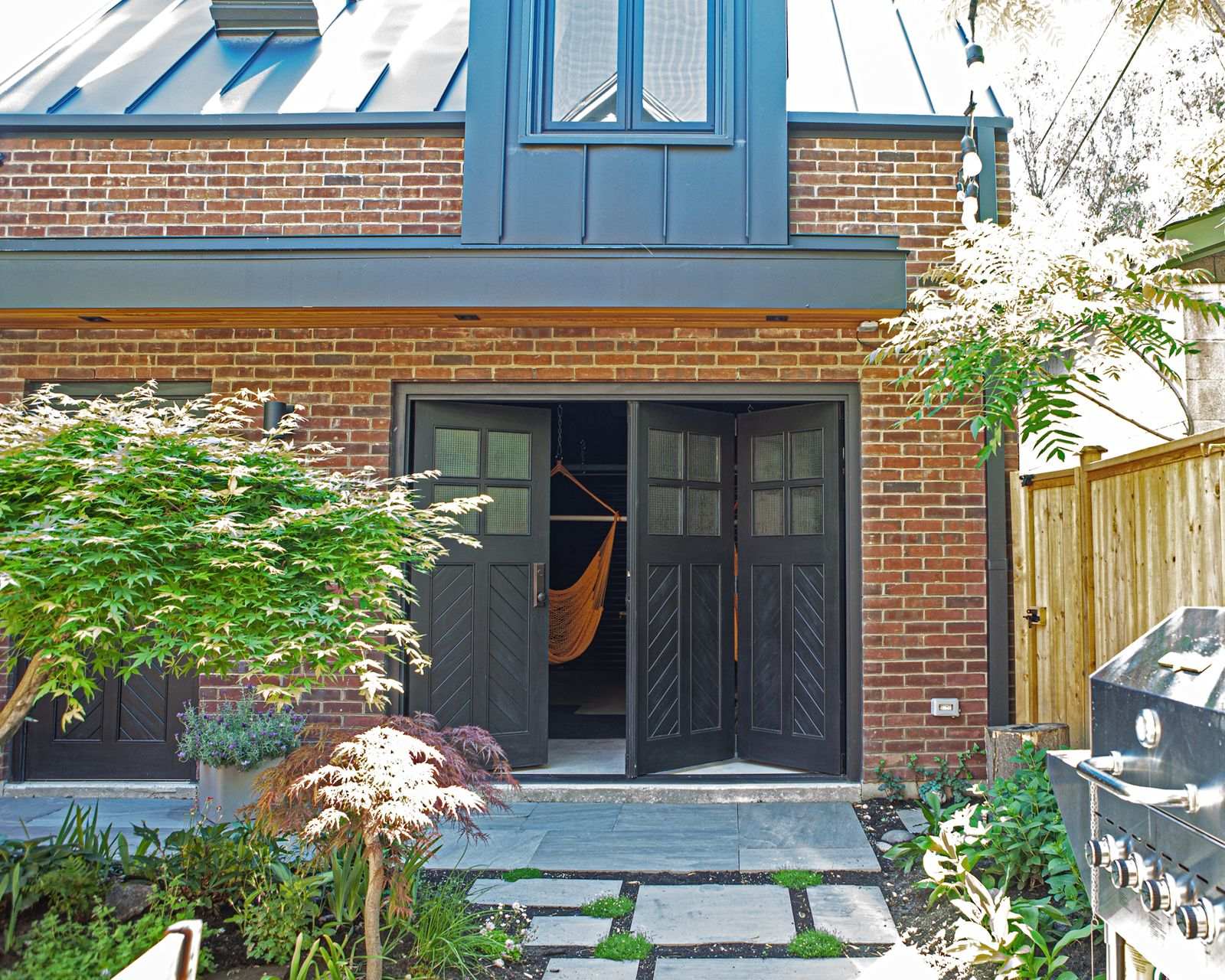 traditional brick carriage house with black bi fold door