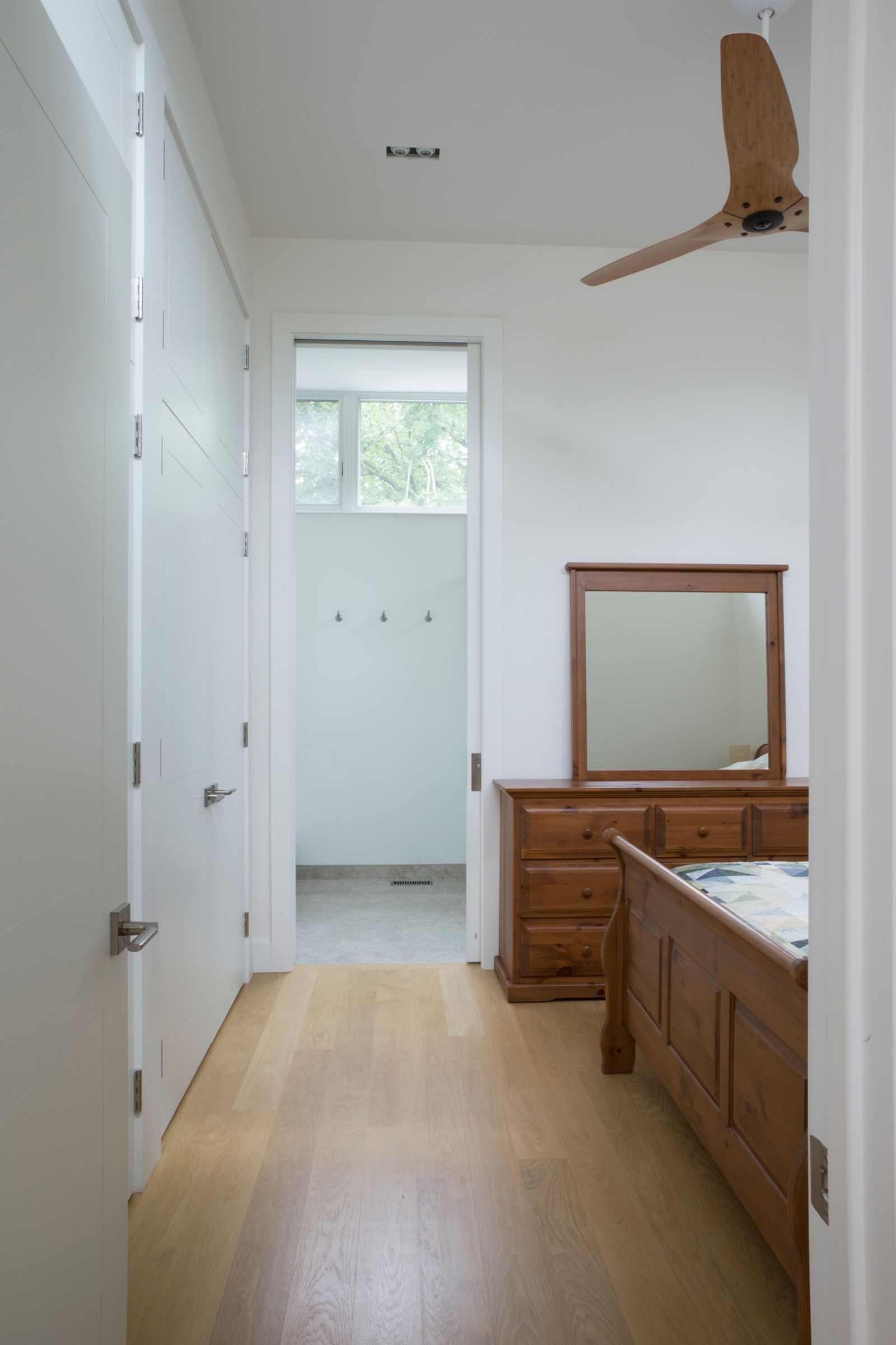 View of bedroom doorway with wooden dresser and mirror in view